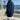 Person wearing a navy blue sweater with a scenic ocean view in the background