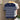 Navy and white striped shirt on a hanger against a wooden panel background